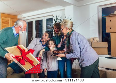 Grandmother And Grandfather Bring A Gift For Moving Into A New Apartment To Their Children