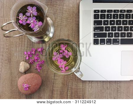 Willow Herb Ivan Tea In Cup Near The Laptop At The Wood Table Workplace