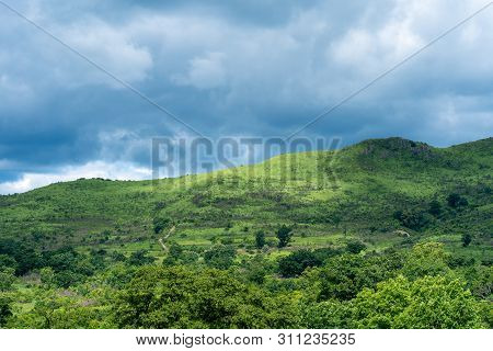 Hill Landscape In The Sunlight Against The Sky With Thunder Clouds