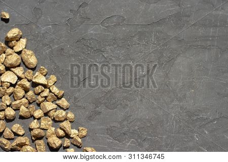 Golden Sones. A Pile Of Gold Nugget Grains, On Gray Cement Background, Copy Space