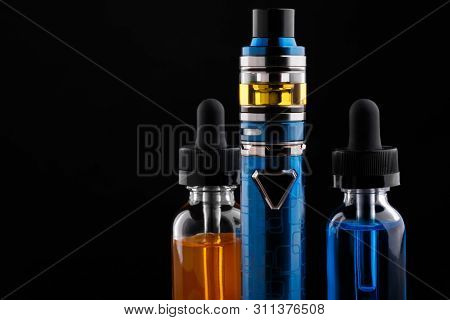 Electronic Cigarette And Bottles With Vape Liquid On Black Background