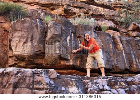 Young Woman Hiker Encounters A Bat On A Narrow Rock Ledge Above Hance Creek In Grand Canyon National