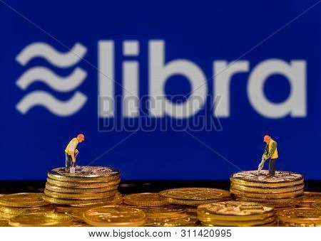 Morgantown, Wv - 14 July 2019: Golden Cybercurrency Coins Stacked In Front Of Display Showing Libra 