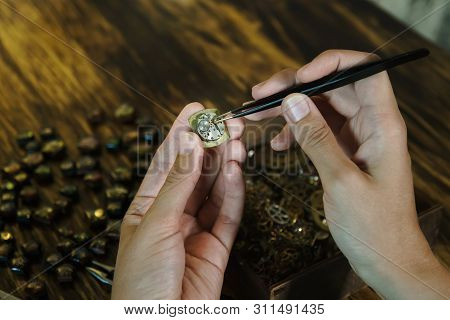 Girl Craftsman Dismantles Clock. Repairing Vintage Watches. Female Hands Holding Tweezers. Disassemb