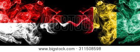 Indonesia Vs Guinea, Guinean Smoky Mystic Flags Placed Side By Side. Thick Colored Silky Smoke Flags