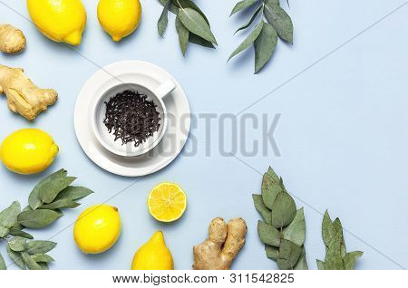 Creative Food Concept. Fresh Ginger Root, Cup Tea With Brewing Inside, Lemon, Eucalyptus Leaves On B