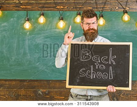 Back To School Concept. Man With Beard And Mustache On Strict Face Warns Students, Chalkboard On Bac