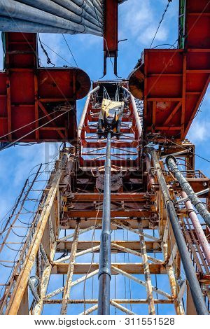 Oil Rig Derrick In Oilfield Against The Bright Blue Sky. Drilling Rig In Oil Field For Drilled Into 