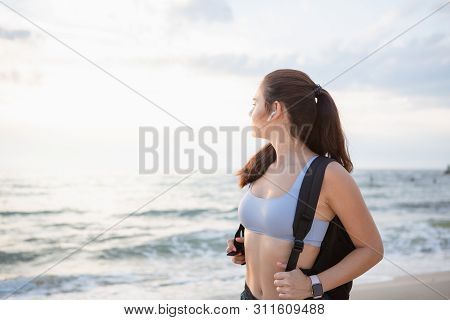 Young Brunette Woman With Wireless Earbuds, Smart Watches And Black Backpack Resting After Morning W