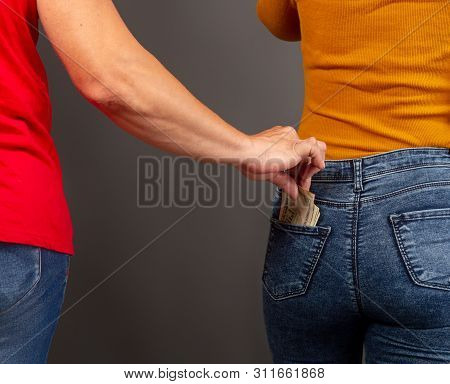 The Thief, Stepping Up Imperceptibly Behind The Girl, Is Trying To Steal Dollar Bills From The Back 