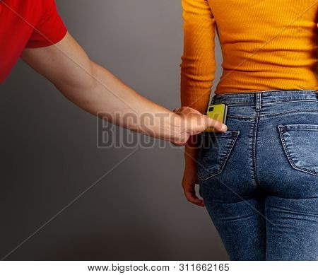 The Thief Stepping Up Imperceptibly Behind The Girl Is Trying To Steal A Smartphone From The Back Po