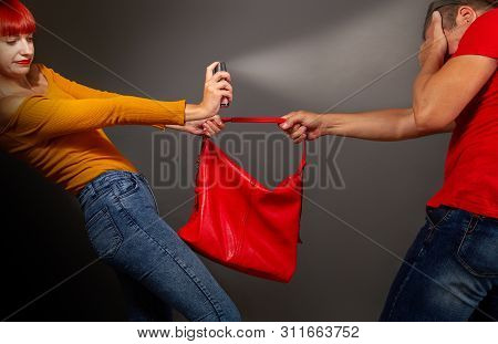 A Girl Defending Pepper Spray From A Robber Who Is Trying To Take Away Her Bag