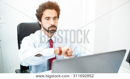 Bored businessman looking at his wrist watch