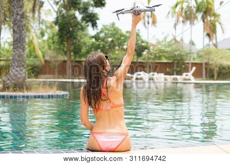 Female Launches A Drone For Flight, With Which You Can Take Photos And Videos, Near The Swimming Poo