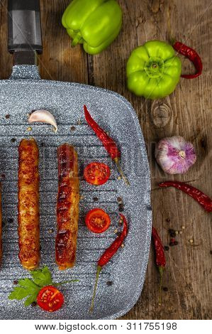 Kupaty In A Frying Pan, Vegetables And Spices. Sausages Grill. Tasty Food.