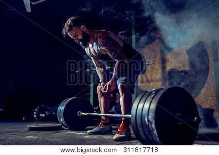 Muscular Fitness Man Preparing To Deadlift A Barbell Over His Head In Modern Fitness Center. Functio