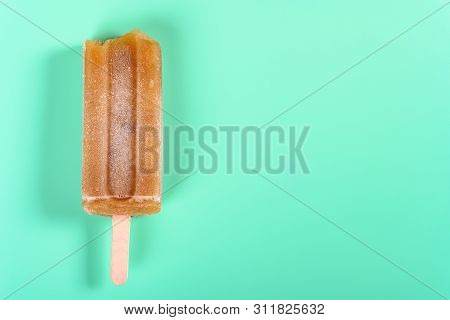 Red Bean Popsicle With Some Bites On Light Green Background