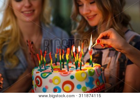 Birthday. The Girls Light Candles On The Cake