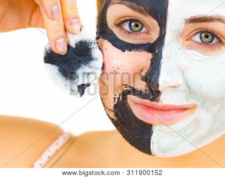 Woman With Clay Carbo Black Mask On One Half Face And White Mud On Second Half. Girl Removing Cosmet