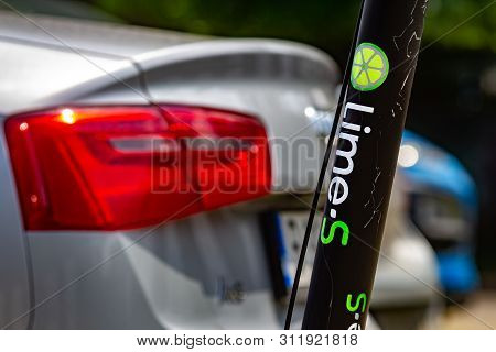 Bucharest, Romania - July 04, 2019: A Lime-S Electric Scooter is parked next to a car on a sidewalk in Bucharest. This image is for editorial use only.
