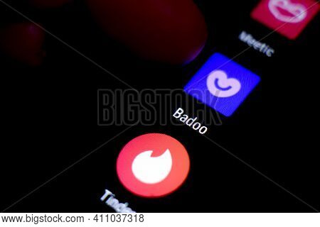 Madrid, Spain- March 3, 2021: Finger Pressing Badoo App Icon Next To Tinder  And Meetic App Icon On 