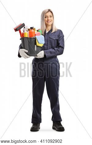 Full length portrait of a female professional cleaner holding a bucket with cleaning supplies isolated on white background