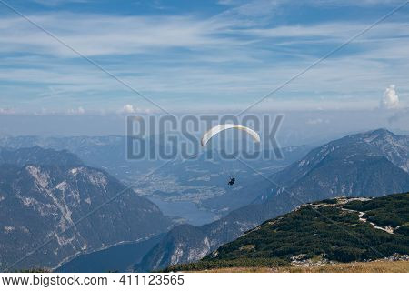 Man With White-and-yellow Parachute Hovers Over Mount Krippenstein In Upper Austria, Enjoying View O