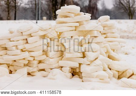 Loosely Built Snow Bricks´ Wall In The Park Where From Distance Is Visible Leafless Winter Trees And