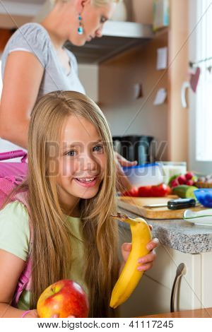 Aile - sabah ve bir aperatif okul çocukları için kahvaltı yapmak anne