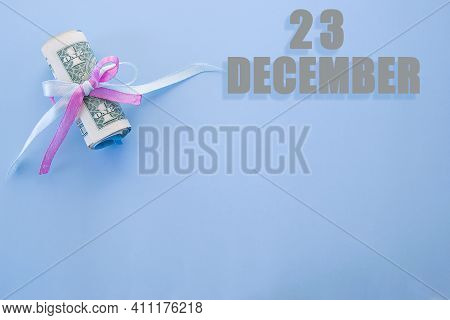 Calendar Date On Blue Background With Rolled Up Dollar Bills Pinned By Blue And Pink Ribbon With Cop