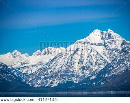 The Mountains In Glacier National Park Are Snow Capped.
