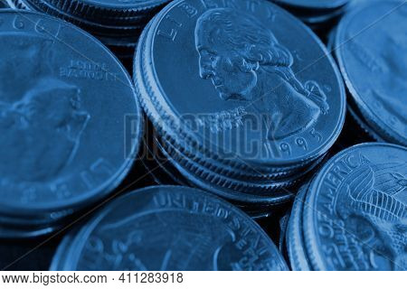 Piles Of Us American Coins Of 25 Cents Quarters Close-up. Dark Blue Tinted Background For News About