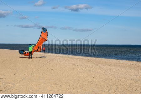Rewa, Poland - March 6, 2021: Kitesurfer On The Beach With Their Kite