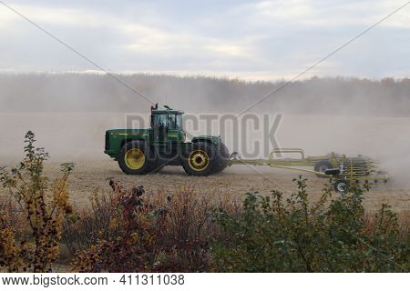 BONNYVILLE, ALBERTA, CANADA - SEPTEMBER 10, 2020: A local farmer in John Deere tractor works with a Degelman Stawmaster to harrow a field after harvest