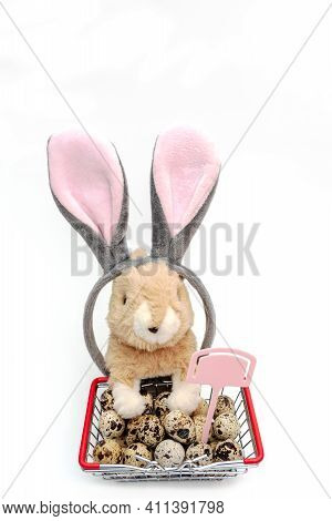 Easter Banny And Quail Eggs In Mini Shopping Basket Isolated On White Background. Rabbit And Soap Na