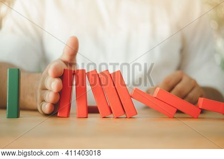 Man His Hands Stopping The Red Domino Falling Into Green Domino. Business Strategy