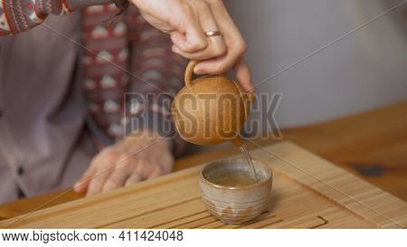 Close-up Of Man Pouring Chinese Tea. Art. Traditional Chinese Tea With Small Teapot On Wooden Tray. 