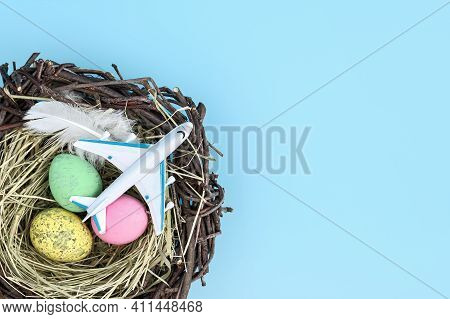 Top View Of Airplane And Easter Egg Nest Flatlay. Spring Season Travel Concept Background. Copy Spac