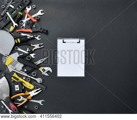 Handyman Tool Kit On Black Wooden Table. Many Wrenches And Screwdrivers, Pilers And Other Tools For 