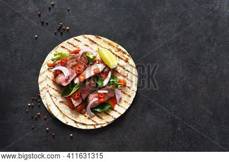 Grilled Beef Steak. Fajitos, Tortillas With Salsa, Chili And Beef On A Dark Background.