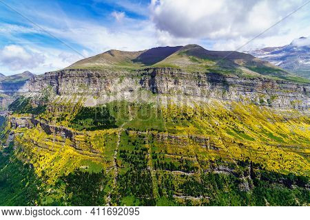 Green Landscape With High Mountains, Green Valleys, Rocks And Forests With Blue Sky And White Clouds