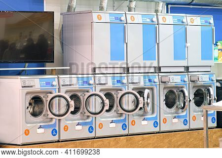 A Number Of Industrial Washing Machines In The Laundry Room. The Concept Of Self-service Dry Cleanin
