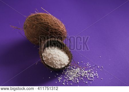 Whole Coconut With Coconuts Flakes On Perple Background