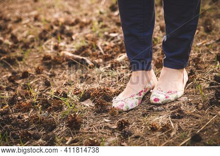Closeup Of A Womans Legs In Pumps And Dark Jeans On The Ground. Sunny Summer Day Outdoors. A Woman W