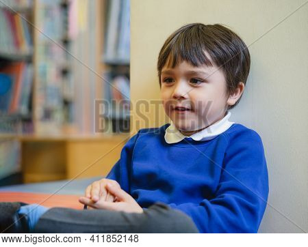 Cropped Shot Of Preschool Kid Sittng On Sofa Enjoy Happy Time In  Library At School, Cute Boy With H