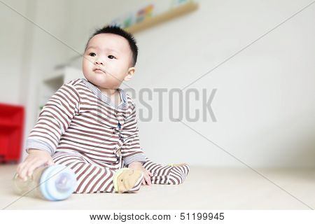 Cute Baby Look Left And Take His Feeding Bottle