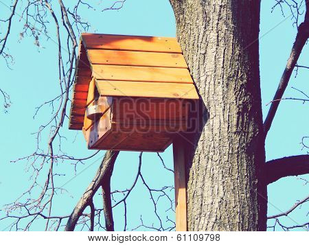 Beautiful wooden birdhouse feeder for birds hanging on a tree
