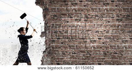 Young attractive businesswoman with hammer in hands