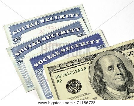 Detail of several Social Security Cards and cash money symbolizing retirement pensions financial safety