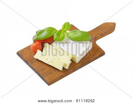 Sliced soft cow's milk cheese on cutting board
